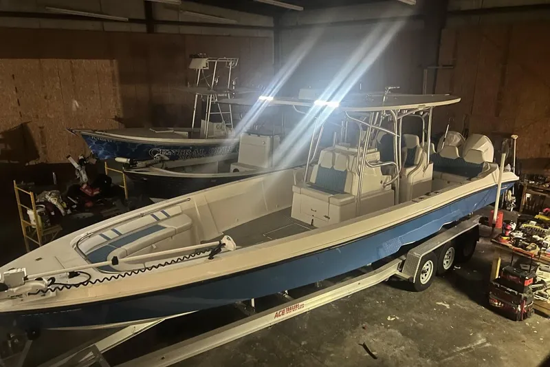 Slide: The Image of 2021 Custom Infusion 34 CC boat in a dimly lit garage on a trailer. - 89