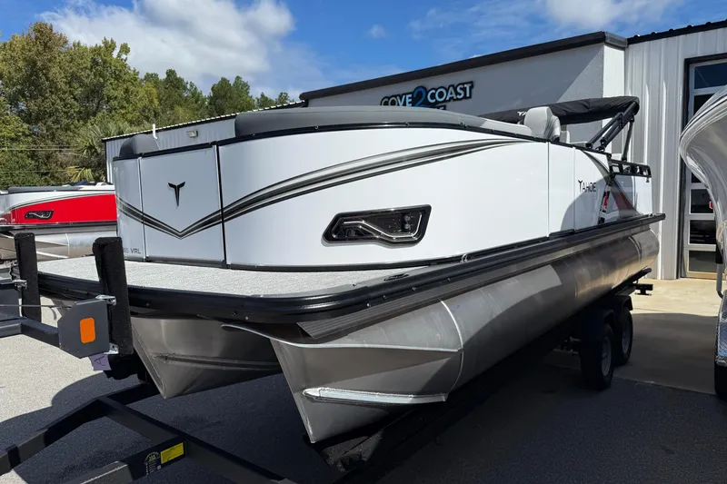Slide: The Image of 2026 Tahoe Pontoon LTZ Versatile Rear Lounger on trailer, parked outside dealership. - 1