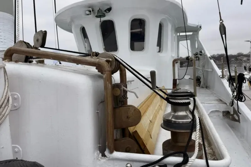 Slide: The Image of 1989 Custom Schooner Liveaboard deck with winch and ropes, docked in a marina. - 5