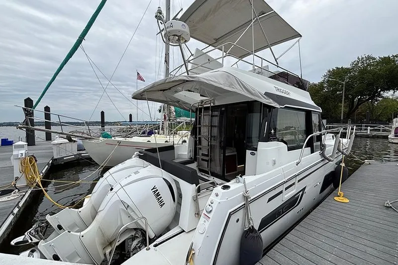 Slide: The Image of 2022 Jeanneau NC Weekender 1095 Fly docked, featuring Yamaha engines and spacious flybridge. - 2