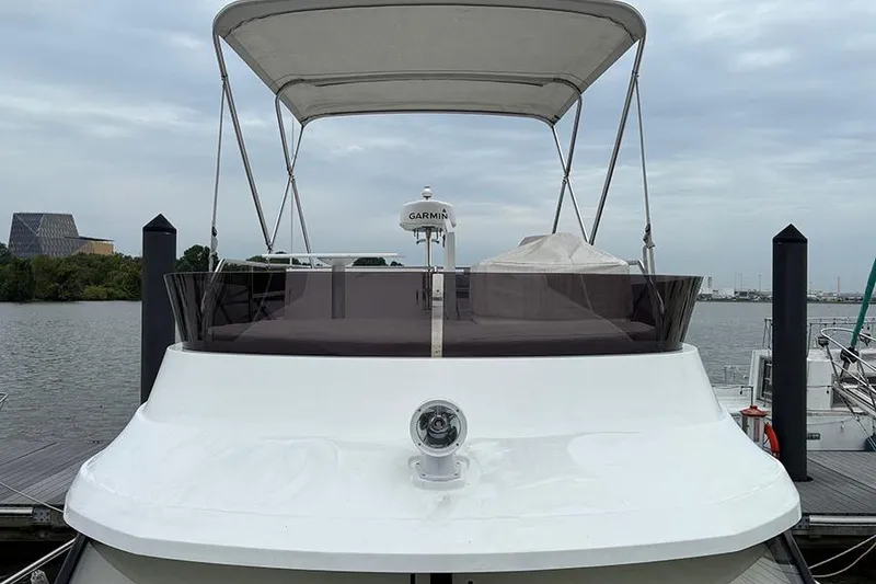 Slide: The Image of 2022 Jeanneau NC Weekender 1095 Fly boat docked in a marina under clear skies. - 4