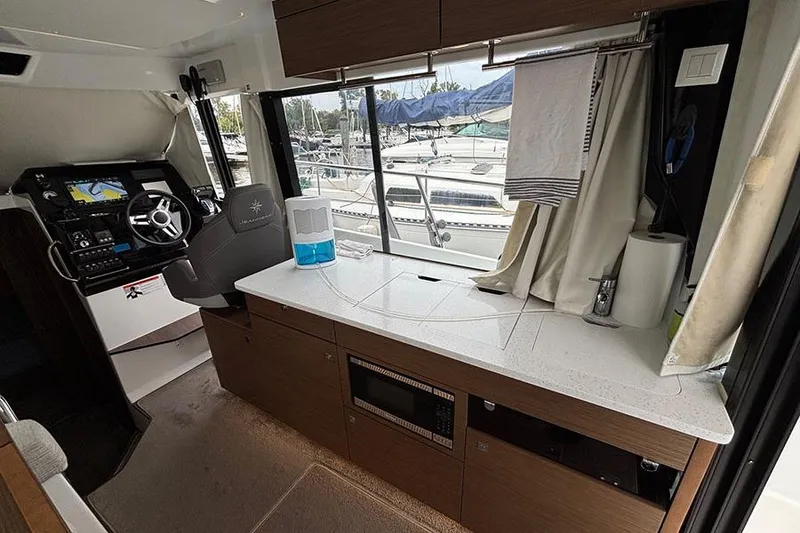 Slide: The Image of Interior of 2022 Jeanneau NC Weekender 1095 Fly, featuring helm and kitchenette. - 55