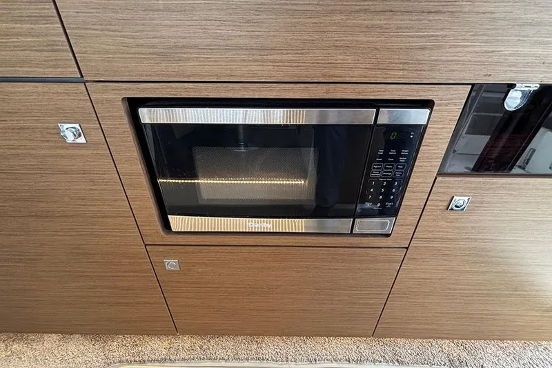 Slide: The Image of Built-in microwave in Jeanneau NC Weekender 1095 Fly, 2022 model, with wood paneling. - 56