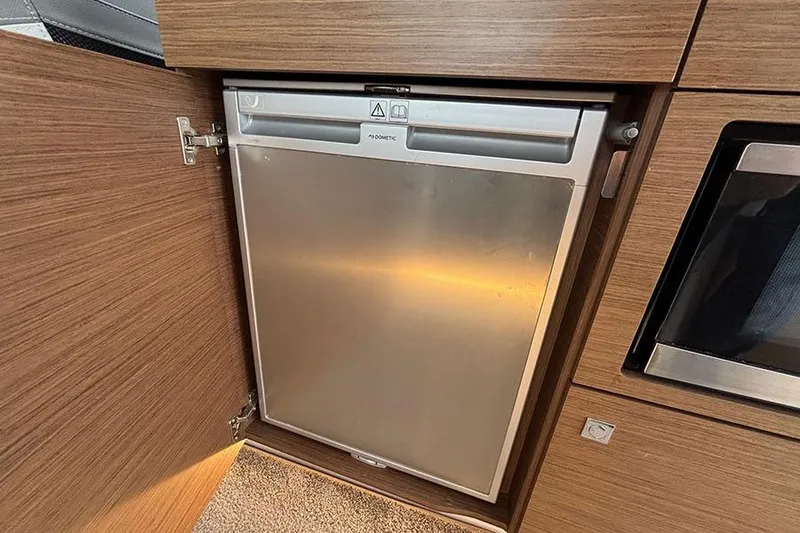 Slide: The Image of Compact fridge in 2022 Jeanneau NC Weekender 1095 Fly boat interior. - 58