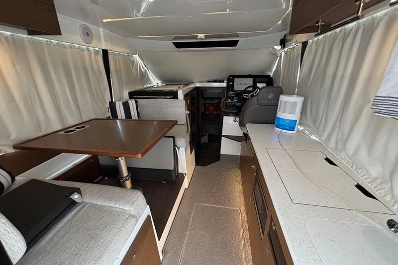 Slide: The Image of Interior of 2022 Jeanneau NC Weekender 1095 Fly, featuring dining area and helm station. - 61