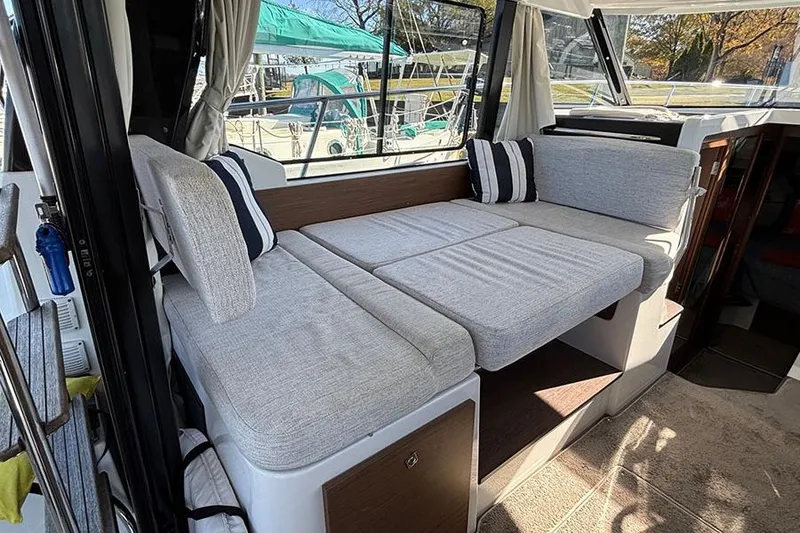 Slide: The Image of 2022 Jeanneau NC Weekender 1095 Fly interior with comfortable seating and striped cushions. - 62