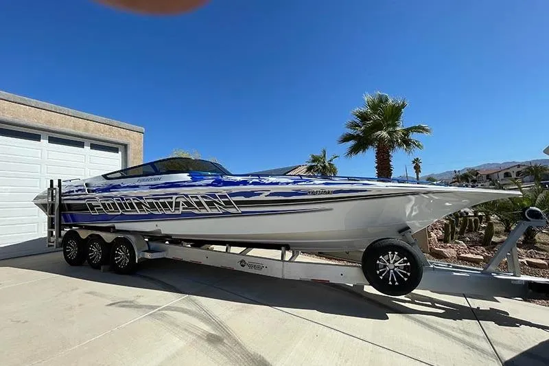 Slide: The Image of 2001 Fountain 35 Lightning speedboat on trailer, parked in sunny driveway. - 12