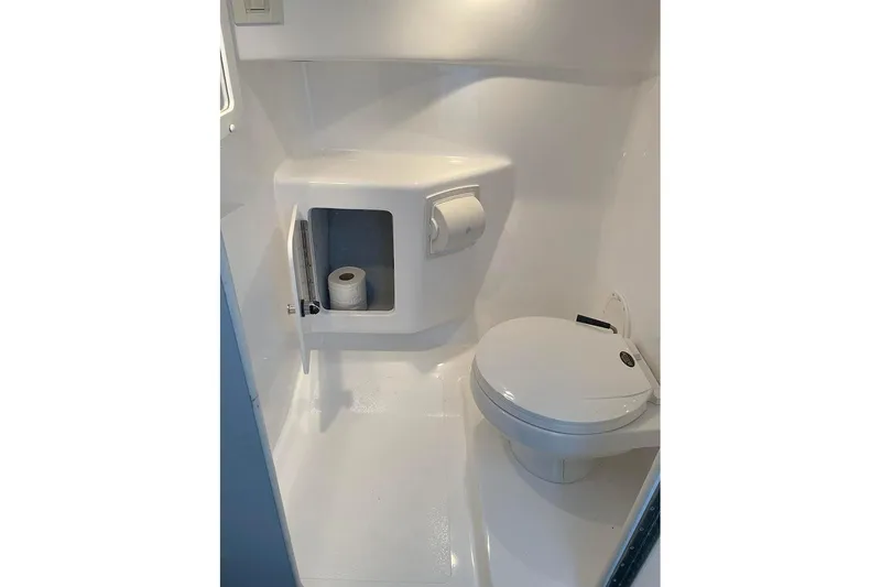 Slide: The Image of Compact bathroom in 2001 Fountain 35 Lightning boat, featuring toilet and storage compartment. - 27