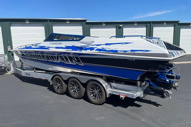Slide: The Image of 2001 Fountain 35 Lightning speedboat on trailer, blue and white design, parked outdoors. - 5