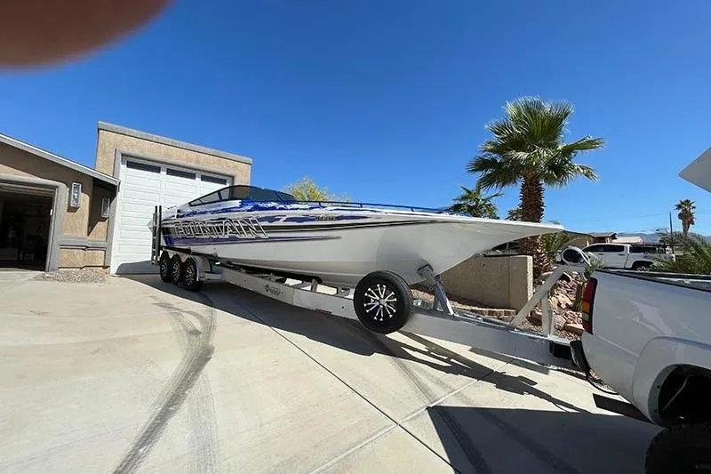 Slide: The Image of 2001 Fountain 35 Lightning boat on trailer in sunny driveway with palm trees. - 9