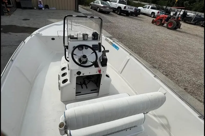 Slide: The Image of 2000 Pathfinder 1806 V boat with steering console, parked near trucks and tractor. - 10