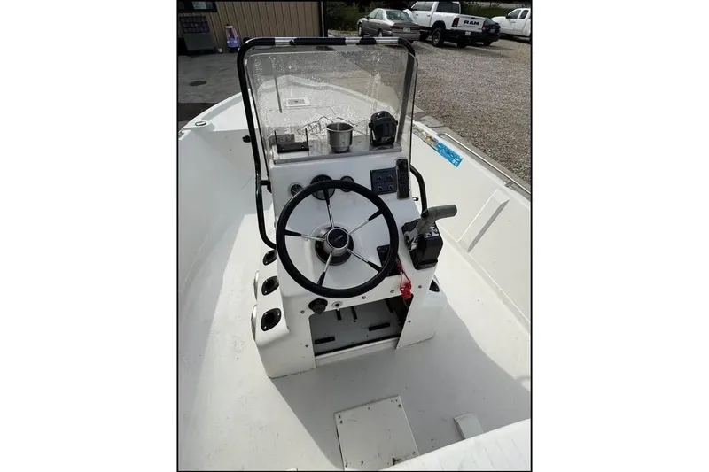 Slide: The Image of Pathfinder 1806 V 2000 boat console with steering wheel and controls, parked outdoors. - 11
