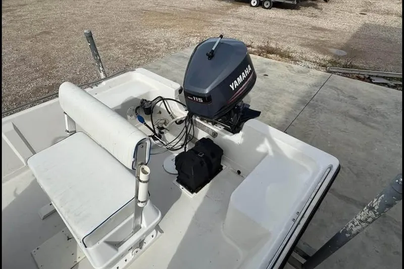 Slide: The Image of 2000 Pathfinder 1806 V boat with Yamaha 115 outboard motor, white seating, and docked on concrete. - 12