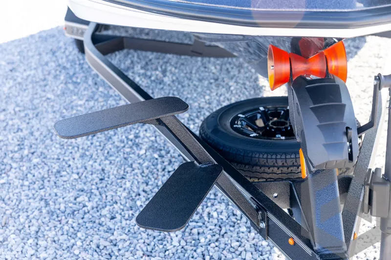 Slide: The Image of Trailer hitch and wheel of 2026 Skeeter ZXE20 on gravel surface. - 12