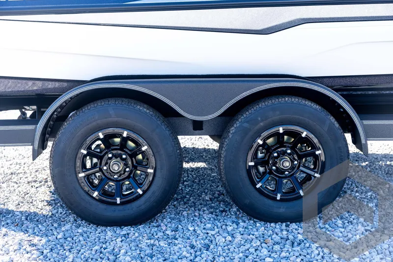 Slide: The Image of 2026 Skeeter ZXE20 trailer wheels on gravel surface, showcasing sleek black rims. - 16