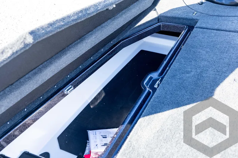 Slide: The Image of Open storage compartment in 2026 Skeeter ZXE20 boat, featuring carpeted interior. - 47