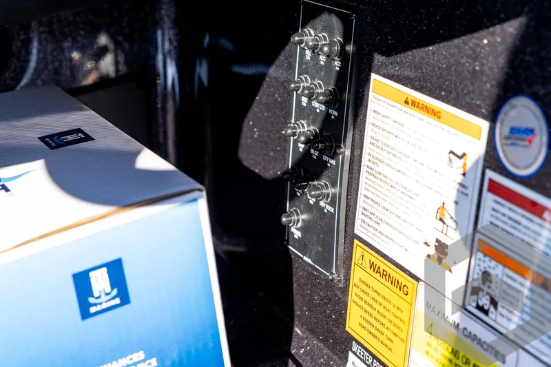 Slide: The Image of Control panel and warning labels on a 2026 Skeeter ZXE20 boat. - 64