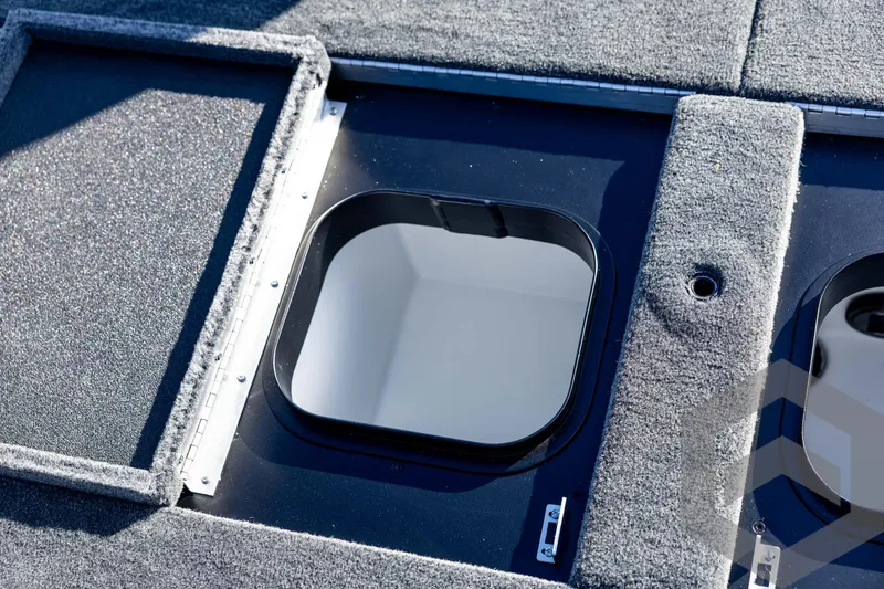Slide: The Image of 2026 Skeeter ZXE20 boat hatch with carpeted deck, open for storage access. - 69