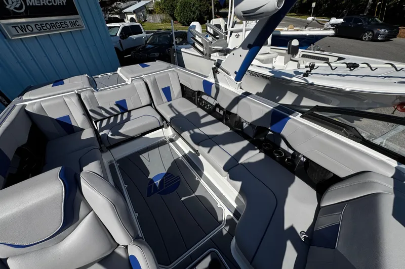 Slide: The Image of 2022 Malibu Wakesetter 23 LSV interior with gray and blue seating, parked outdoors. - 18