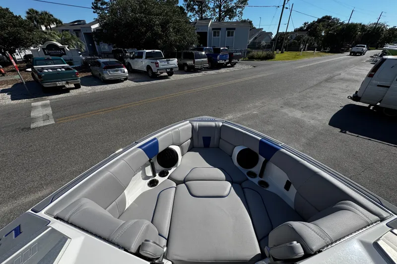 Slide: The Image of 2022 Malibu Wakesetter 23 LSV boat interior with gray seating, parked on a street. - 24