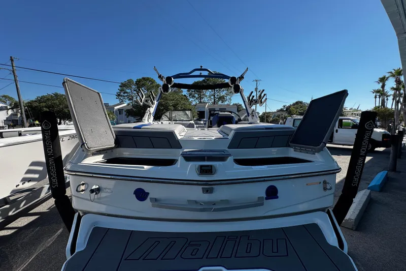 Slide: The Image of 2022 Malibu Wakesetter 23 LSV boat, rear view, parked outdoors under clear blue sky. - 26