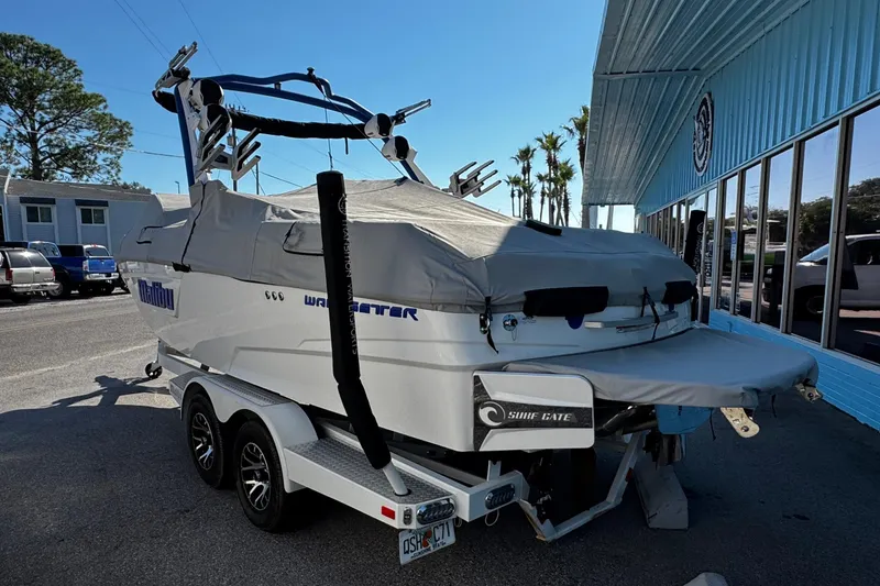 Slide: The Image of 2022 Malibu Wakesetter 23 LSV boat on trailer, covered, parked outside a building. - 9