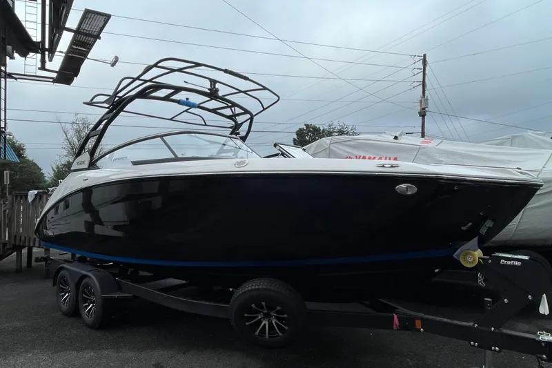 The Image of 2026 Yamaha Boats 252SE on trailer, sleek black design, parked outdoors. - 0