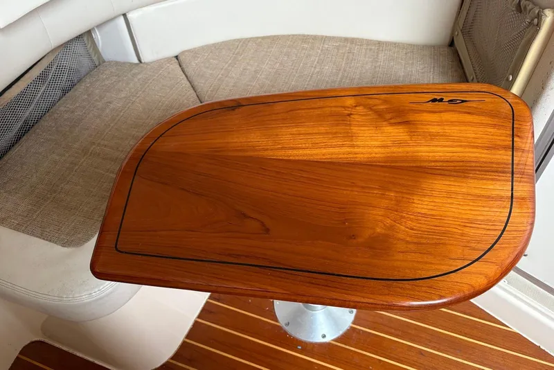 Slide: The Image of Wooden table on 2004 Grady-White Express 330 boat, with cushioned seating and striped flooring. - 9