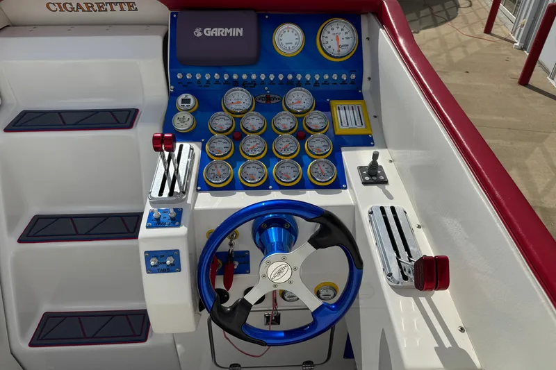 Slide: The Image of 2004 Cigarette 42 Tiger boat dashboard with Garmin navigation and multiple gauges. - 11