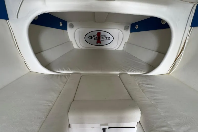 Slide: The Image of Interior cabin of a 2004 Cigarette 42 Tiger boat, featuring white cushioned seating. - 16