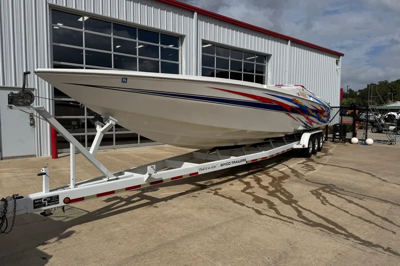 Slide: The Image of 2004 Cigarette 42 Tiger speedboat on trailer outside a garage, featuring vibrant graphics. - 5