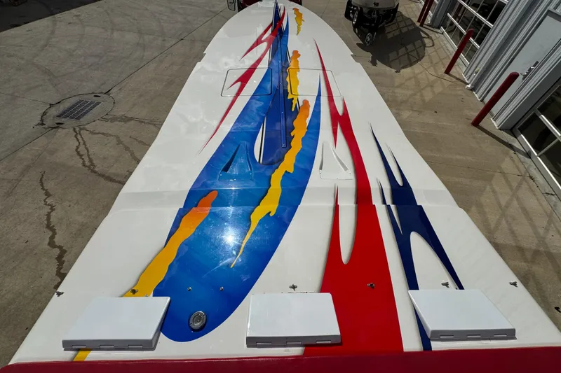 Slide: The Image of 2004 Cigarette 42 Tiger boat with vibrant red, blue, and yellow graphics on deck. - 9