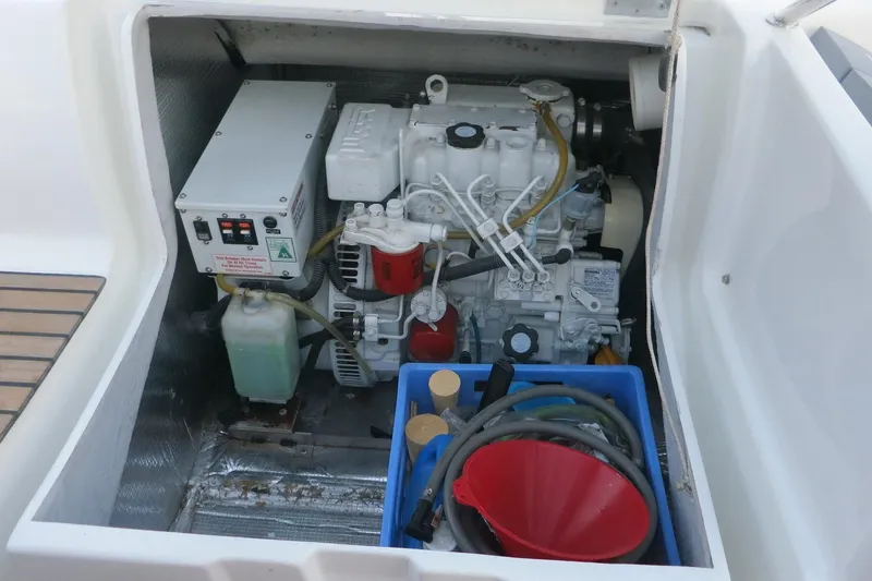 Slide: The Image of Engine compartment of 2002 Jeanneau Sun Odyssey 45.2 sailboat, featuring mechanical components and tools. - 12