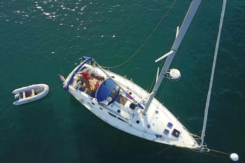 Slide: The Image of Aerial view of 2002 Jeanneau Sun Odyssey 45.2 sailboat with dinghy on calm water. - 2