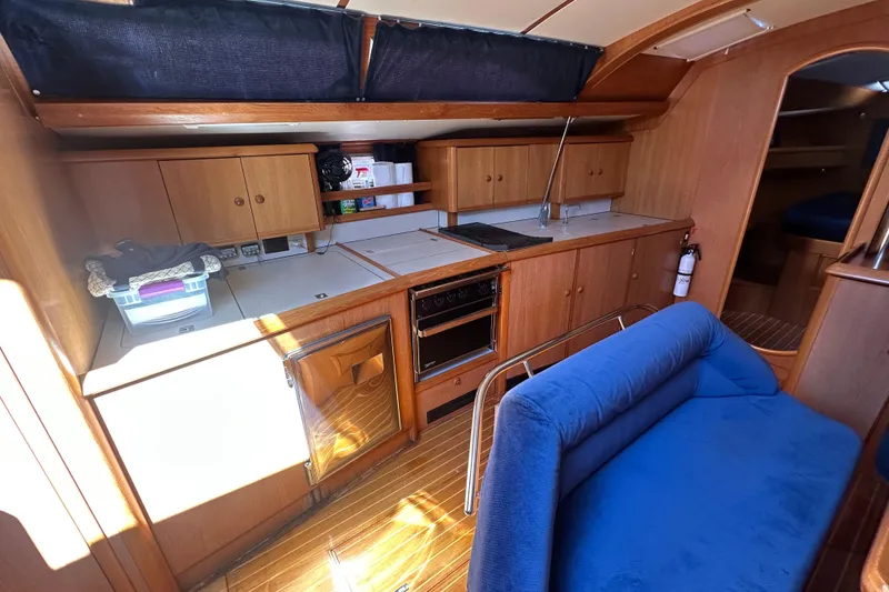 Slide: The Image of Interior of 2002 Jeanneau Sun Odyssey 45.2 yacht with wooden cabinetry and blue seating. - 21