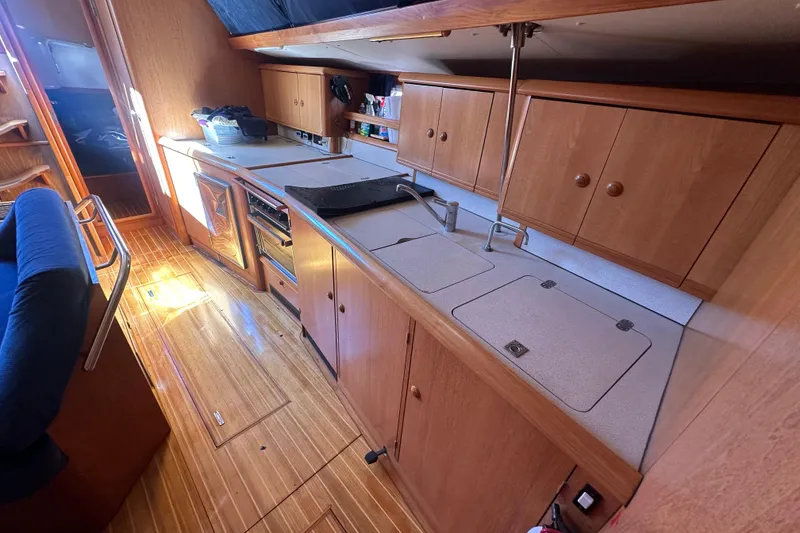 Slide: The Image of Galley kitchen in 2002 Jeanneau Sun Odyssey 45.2 sailboat with wooden cabinetry. - 27