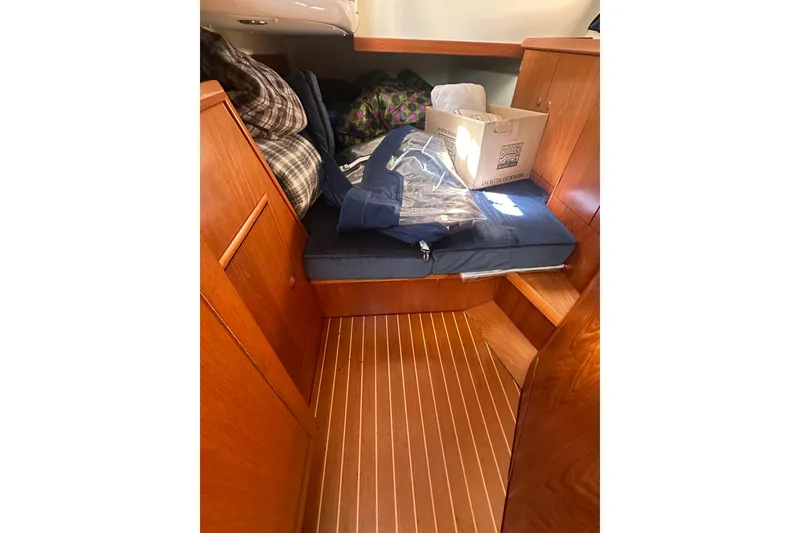 Slide: The Image of Interior cabin of 2002 Jeanneau Sun Odyssey 45.2 with wooden finish and storage items. - 33