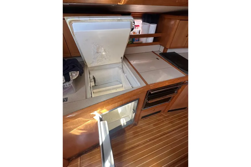 Slide: The Image of Galley of 2002 Jeanneau Sun Odyssey 45.2 with open fridge and wooden cabinetry. - 35