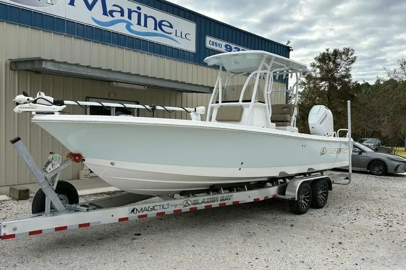 Slide: The Image of 2026 Blazer Bay 2700 Hybrid boat on trailer outside marine dealership. - 13