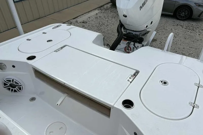 Slide: The Image of 2026 Blazer Bay 2700 Hybrid boat deck with storage compartments and outboard motor. - 18