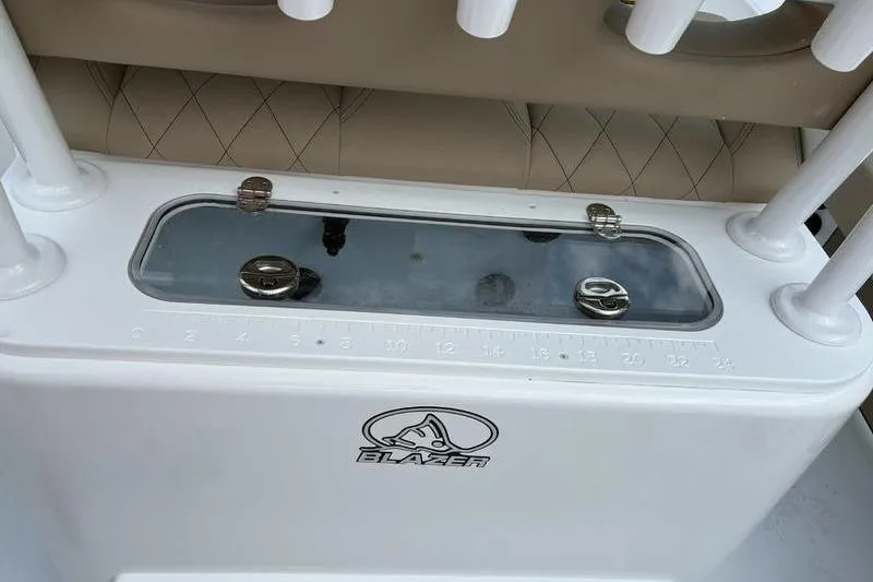 Slide: The Image of 2026 Blazer Bay 2700 Hybrid boat console with rod holders and measurement scale. - 2