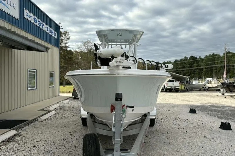 Slide: The Image of 2026 Blazer Bay 2700 Hybrid boat on trailer, parked outside a building under cloudy sky. - 4