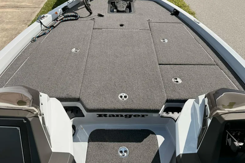 Slide: The Image of 2022 Ranger Z518 boat deck with gray carpet and storage compartments. - 2