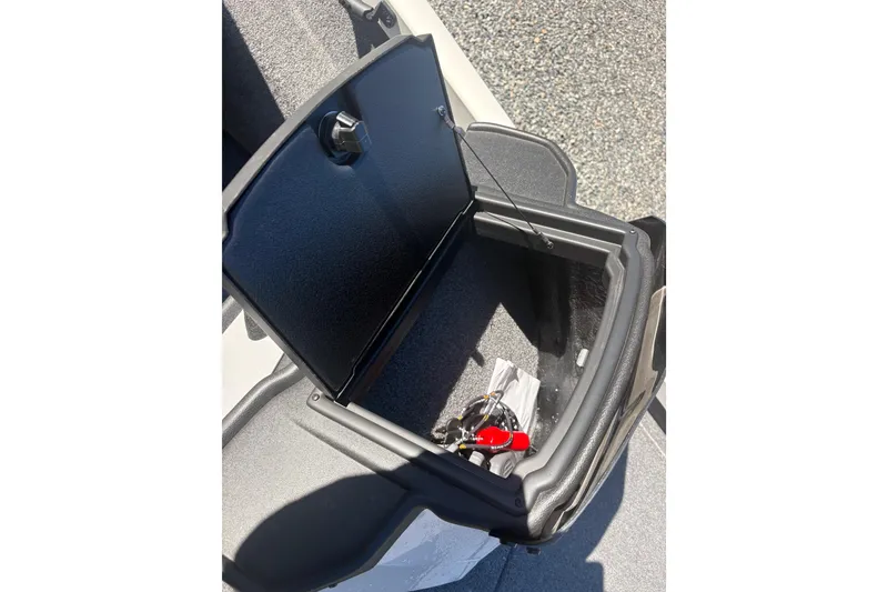 Slide: The Image of Open storage compartment in 2022 Boomeranger 198P boat, showing interior details and keys. - 11