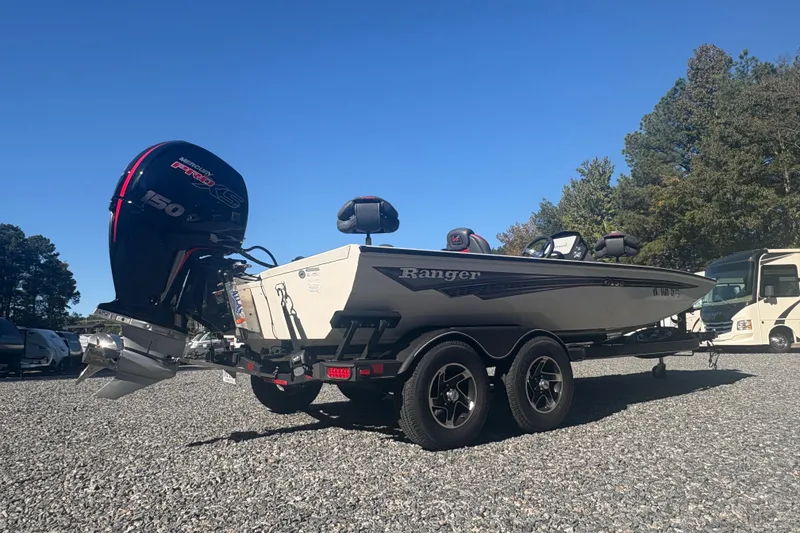 Slide: The Image of 2022 Boomeranger 198P boat with powerful outboard motor, parked on gravel lot. - 3