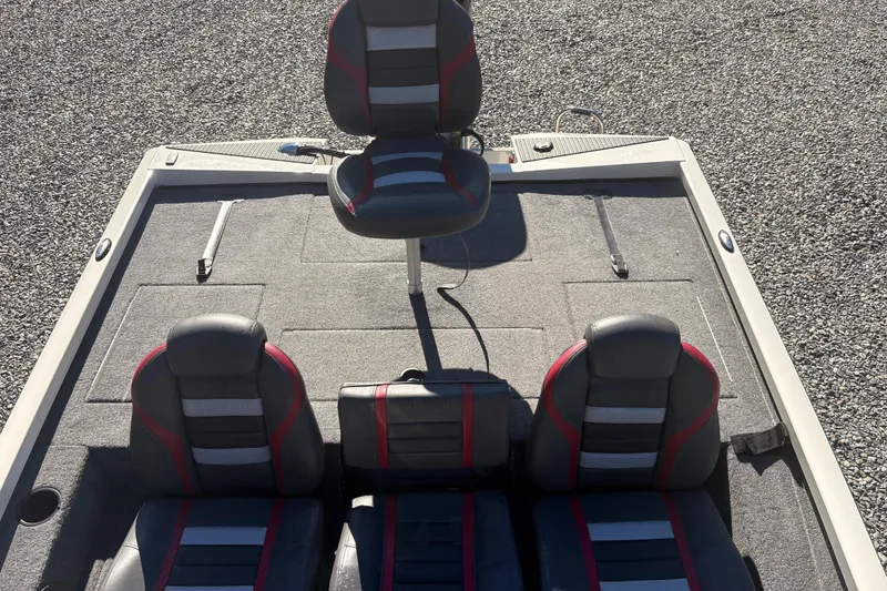 Slide: The Image of 2022 Boomeranger 198P boat interior with four black and red seats on a gray deck. - 6
