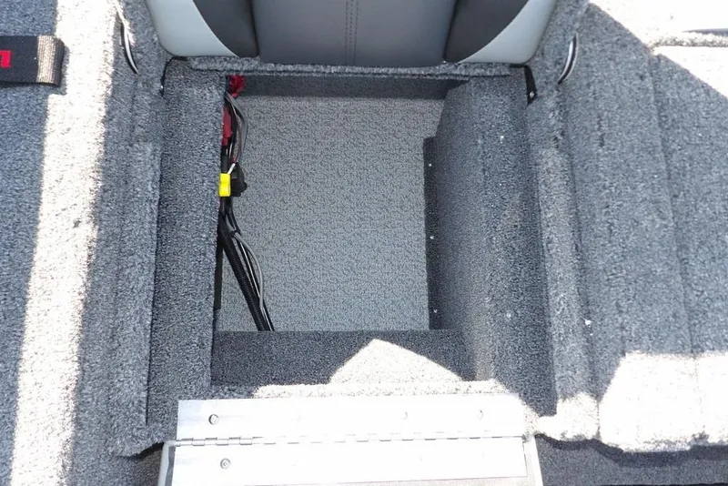 Slide: The Image of 2026 Lund 2075 Impact XS boat storage compartment with carpeted interior and wiring. - 17