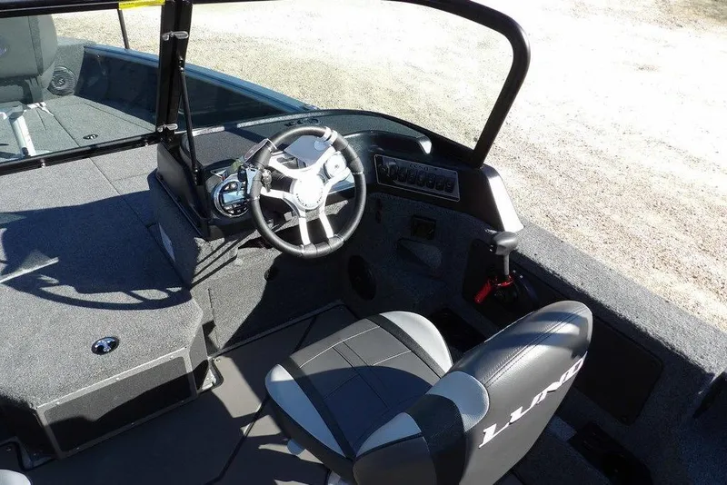 Slide: The Image of 2026 Lund 2075 Impact XS boat interior with steering wheel and seating. - 18