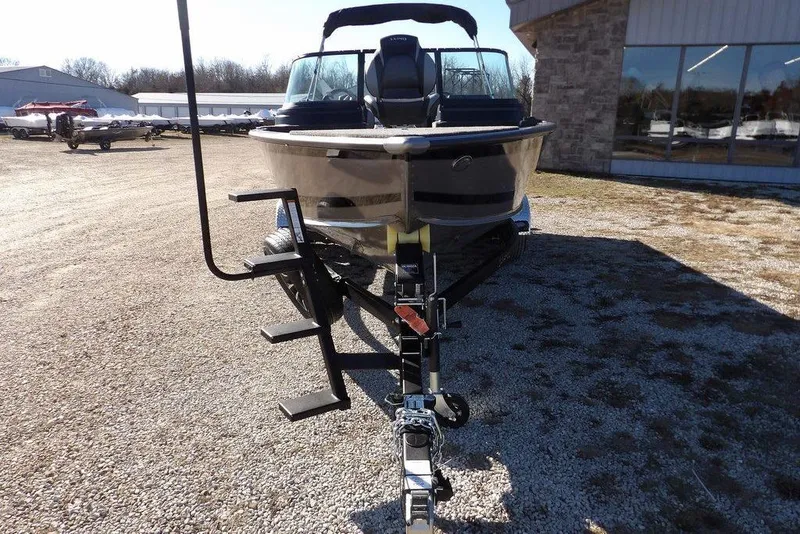 Slide: The Image of 2026 Lund 2075 Impact XS boat on trailer, parked outdoors near a building. - 3