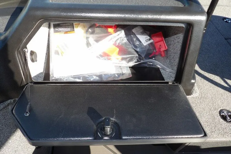 Slide: The Image of Open storage compartment in 2026 Lund 2075 Impact XS boat, containing various items. - 35